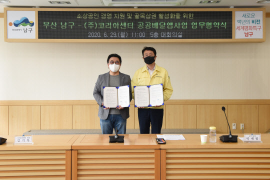 코리아센터가 부산 남구청과 공공배달앱 개발을 위한 MOU를 체결했다. 사진은 29일 협약식에서 기념촬영 중인 김기록 코리아센터 대표(왼쪽)와 박재범 부산 남구청장(오른쪽). <코리아센터 제공>